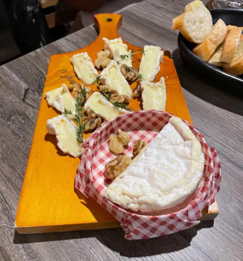 Tabla de quesos con camembert entero, nueces y pan