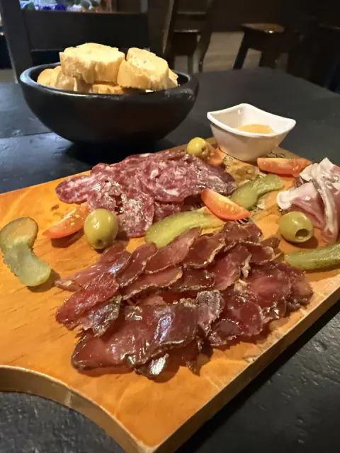 Tabla de charcutería con jamón, salami, aceitunas y pan